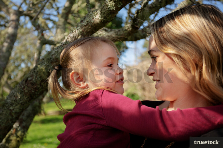 Daughter Hugging Mother in Backyard