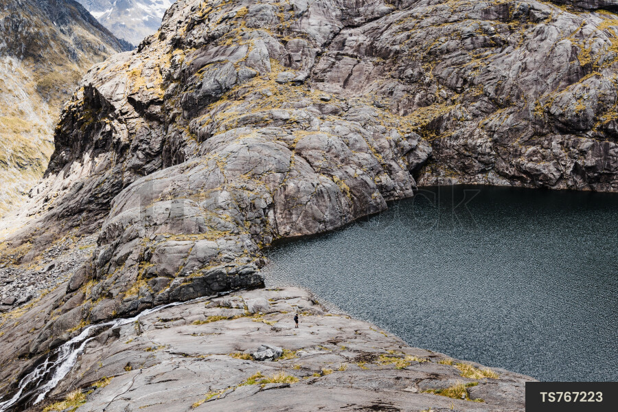 Aerial view of hiker on mountain looking at lake