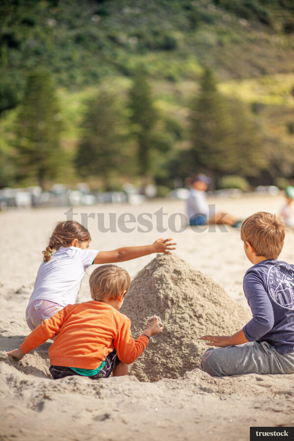 Children playing with sand at the beach