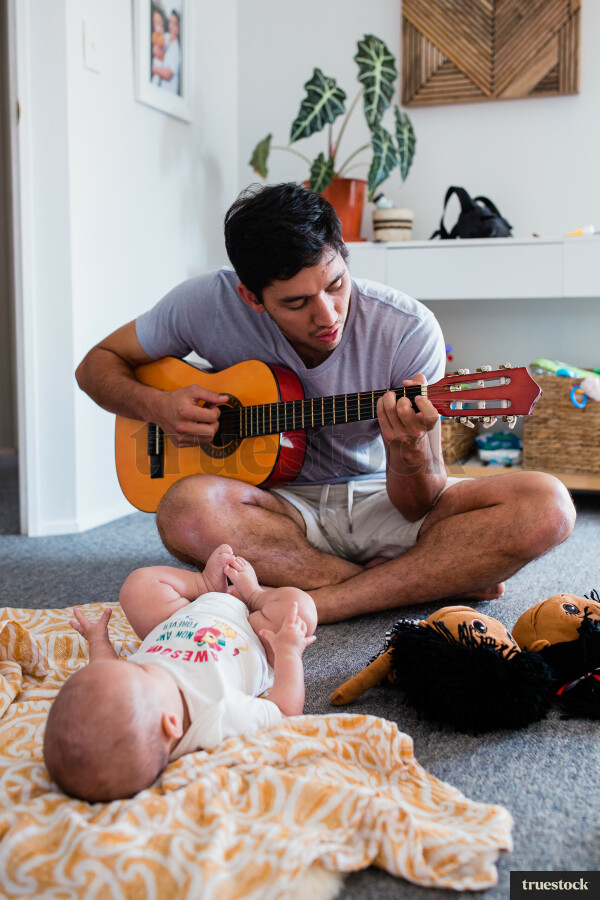 Father playing guitar with baby