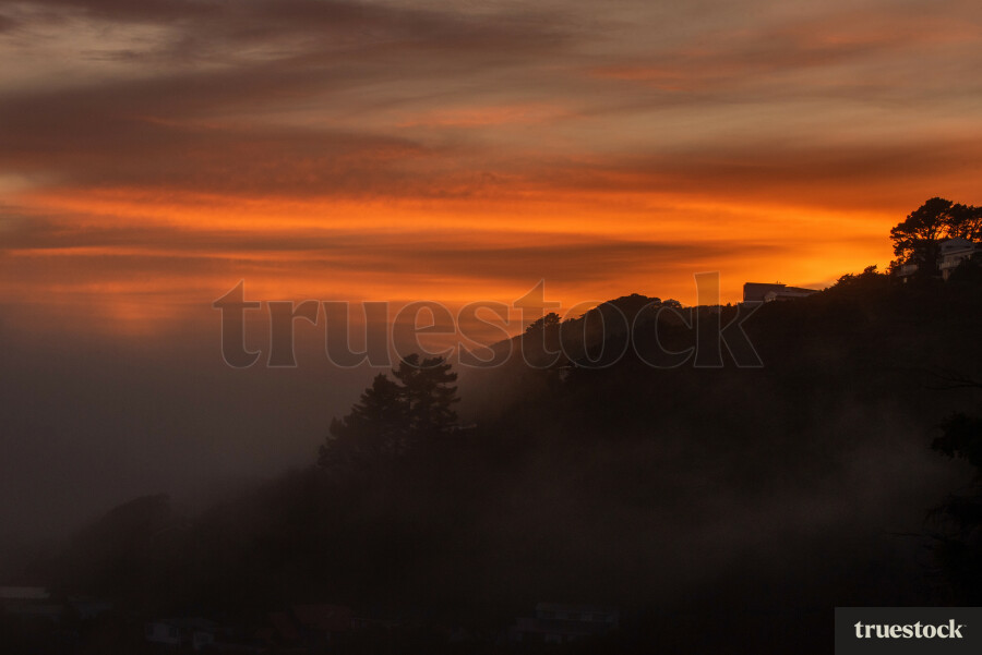 Sunset over the hilltop with low hanging clouds
