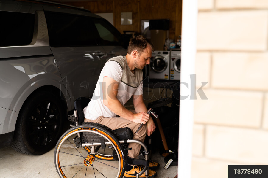 Man in wheelchair doing DIY in garage