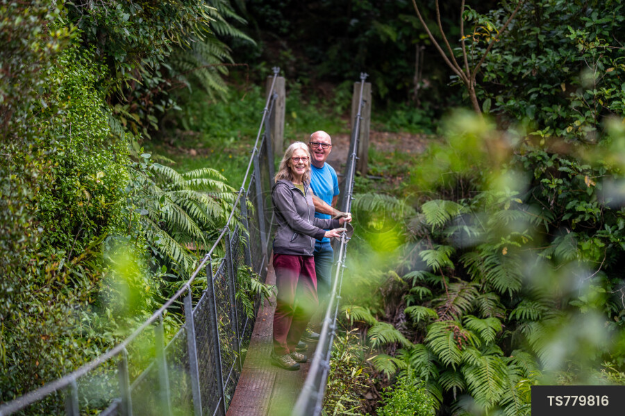 Couple hiking on bridge in forest
