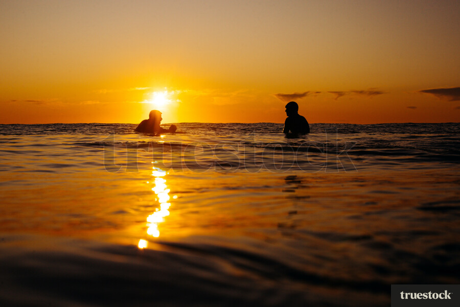 Surfers in Ocean at Sunrise