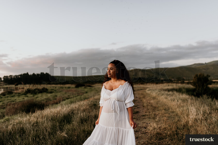 Woman Standing in Field for Maternity Shoot