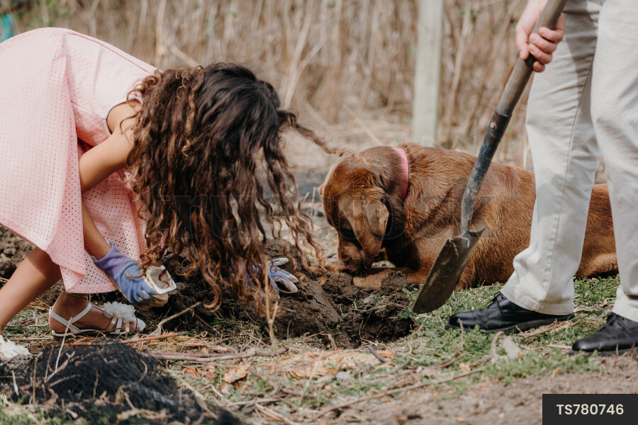 Young Girl Digging Hole in Ground