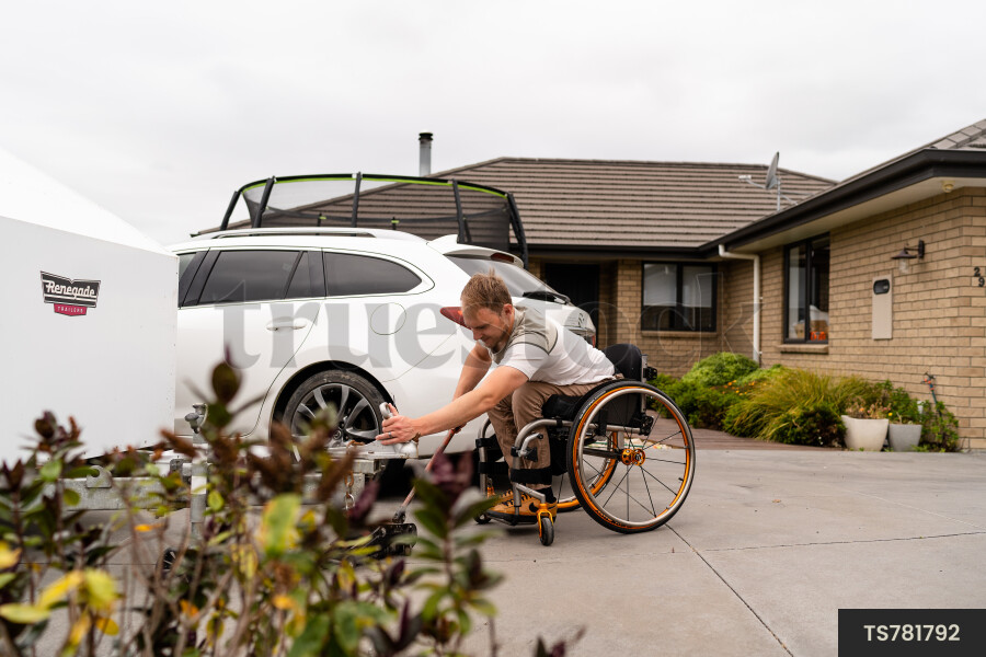 Man in wheelchair using trailer jack