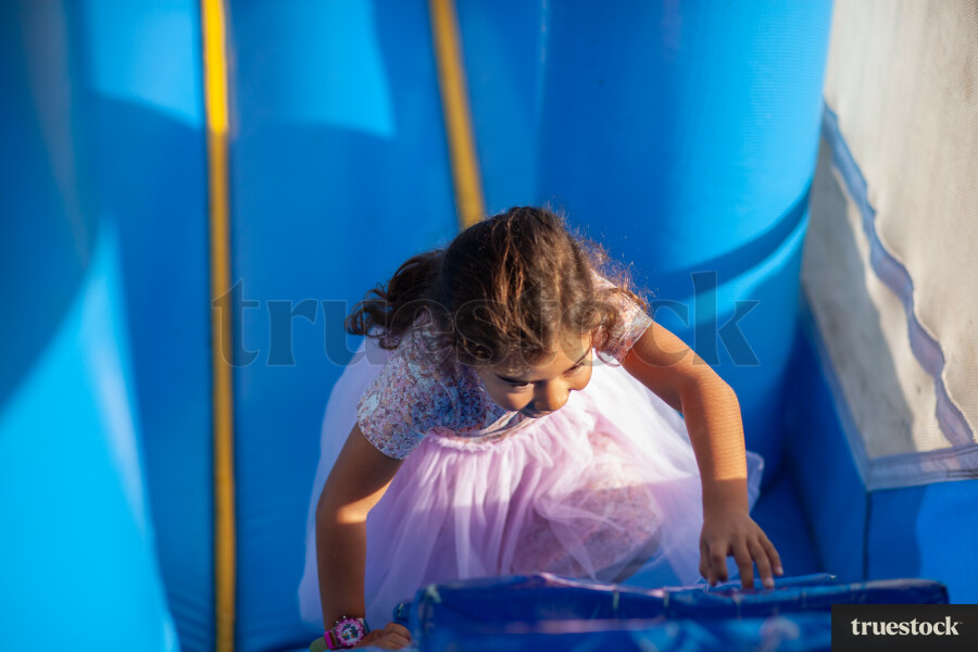 Child climbing and bouncing in the inflatable bouncy castle