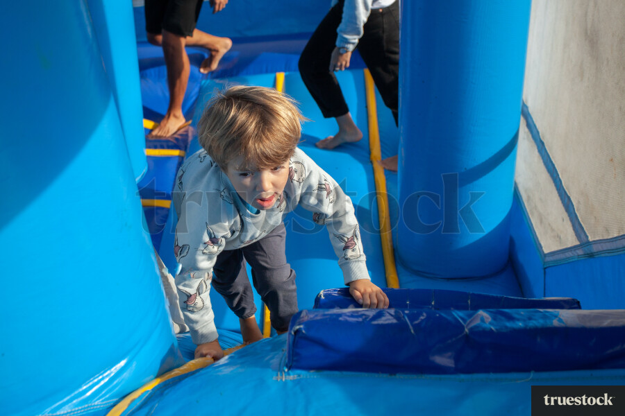 Child climbing and bouncing in the inflatable bouncy castle