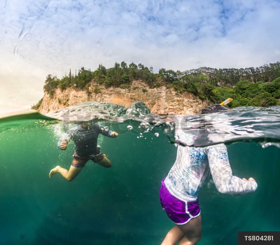 Brother and sister scuba diving in sea