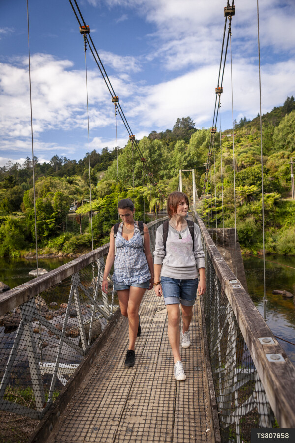 Teenage girls hiking on bridge in Karangahake Gorge