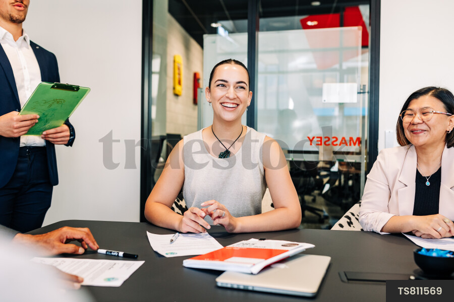 Businesspeople smiling during meeting in boardroom