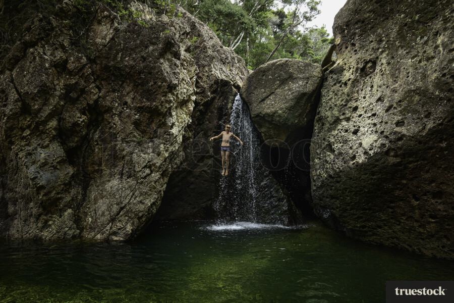 Boy Jumping off Rocks into the Water