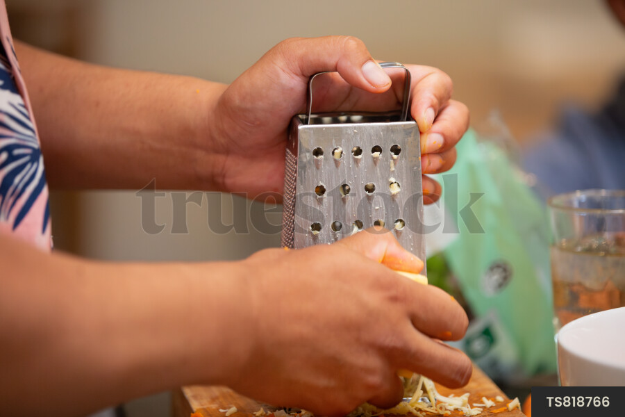 Hands of man grating cheese