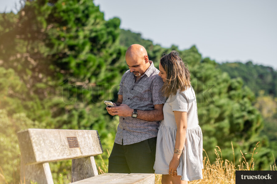 Couple Using Phone on Walk