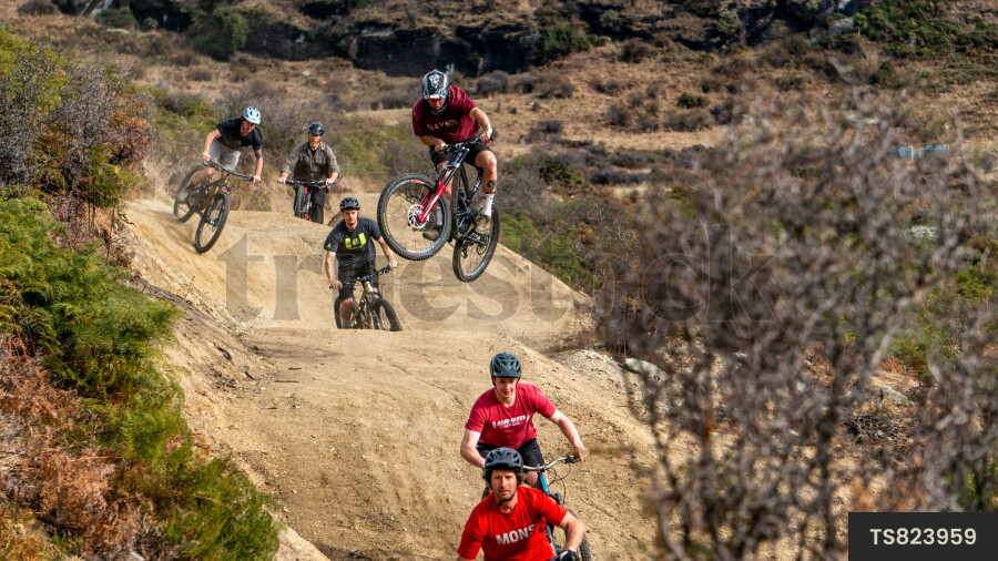 Men mountain biking on dirt trail