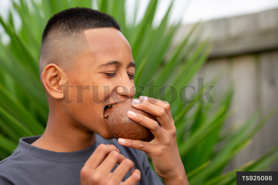 Happy tongan boy eating chocolate easter egg