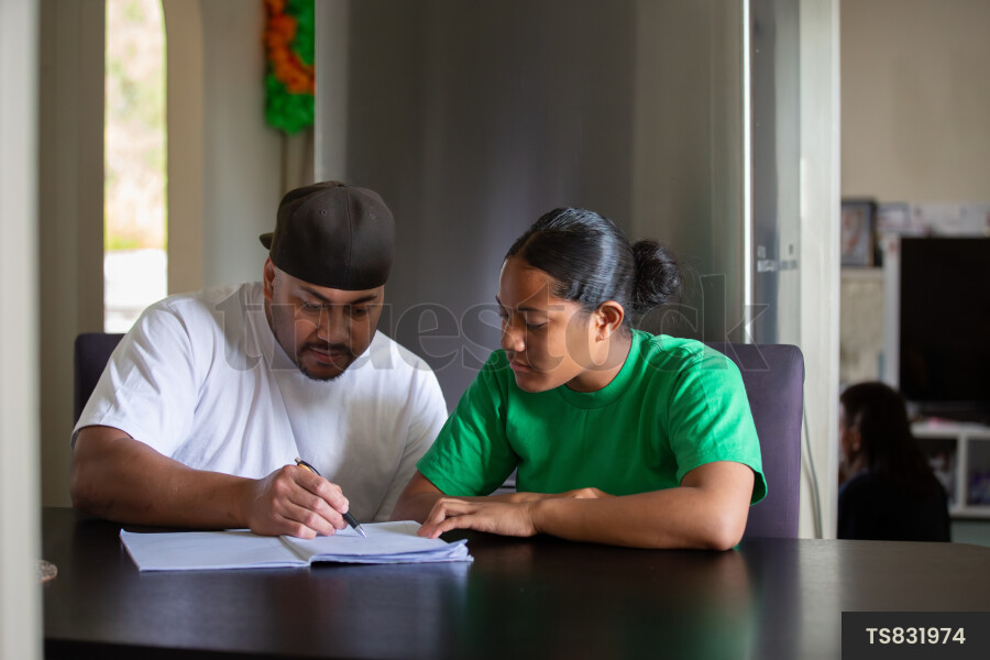 Tongan father doing homework with daughter