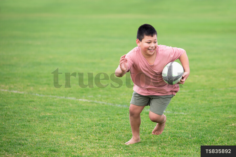 Family Playing Rugby at School Field