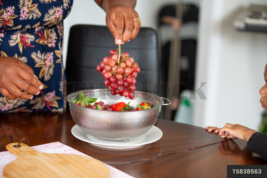 Hands of woman serving grapes for afternoon tea