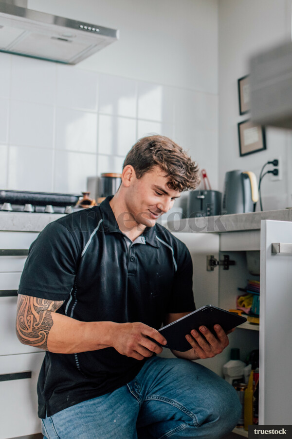 Tradie Using iPad in Kitchen