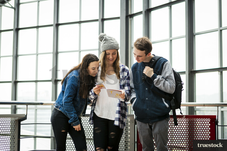 Teenagers in Buidling Looking at Device