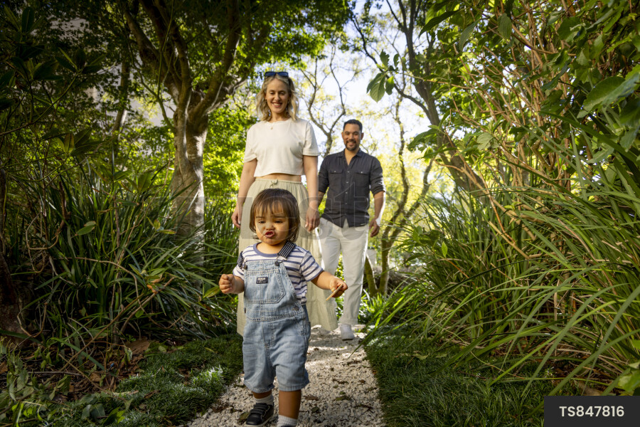 Happy parents walking behind son in park