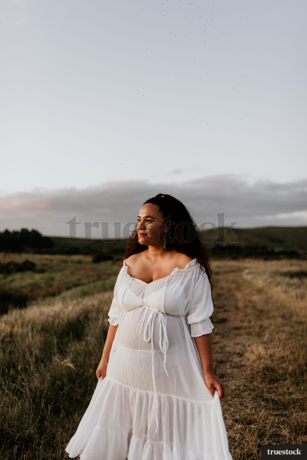 Woman Standing in Field for Maternity Shoot