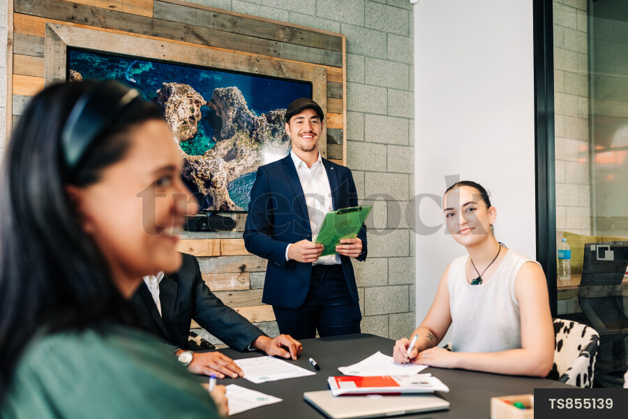Businesspeople smiling during meeting in boardroom