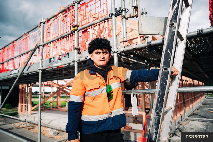 Portrait of man by ladder on construction site
