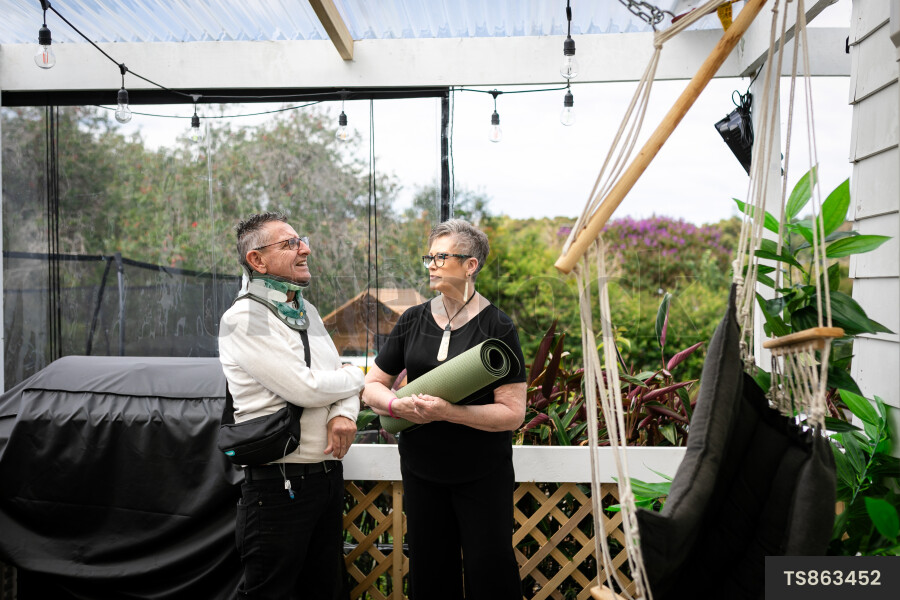 Health carer with yoga mat and patient on deck