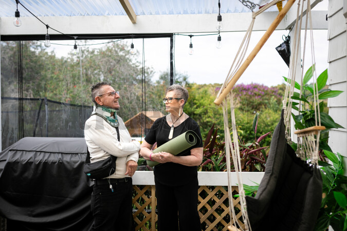 Health carer with yoga mat and patient on deck