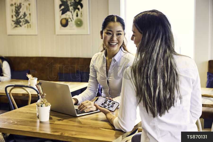 Women working remotely with laptop in cafe
