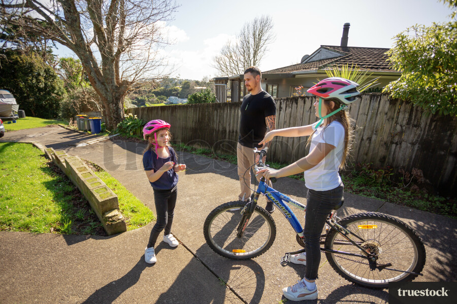 Father Watching Daughters use Bike