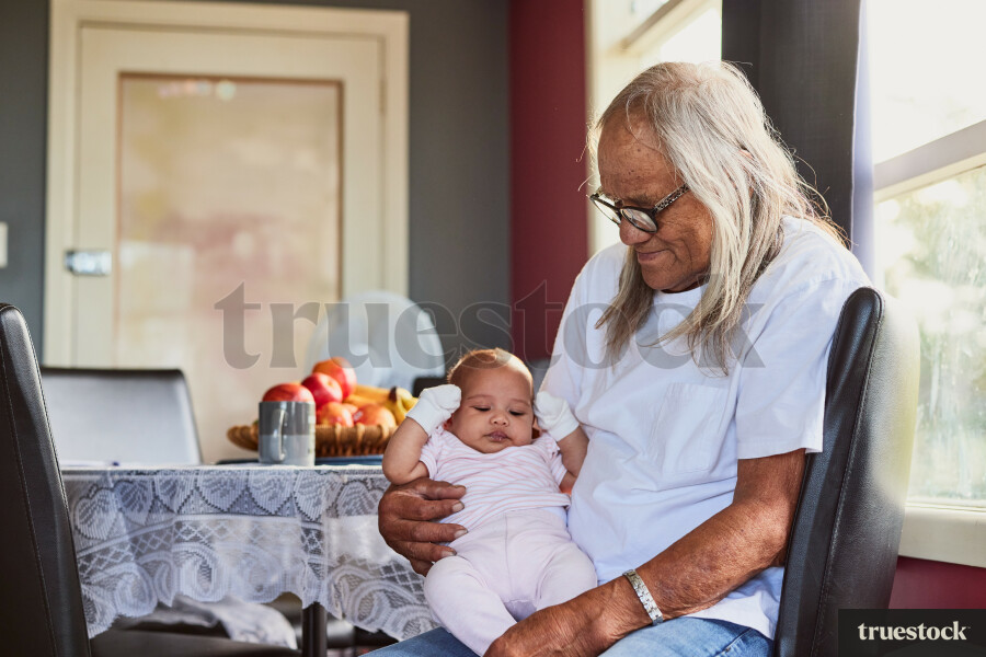 Grandfather Holding Granddaughter in Dining Room
