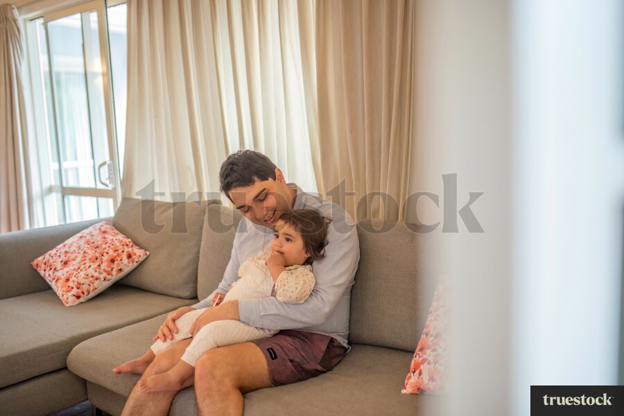 Father Holding Daughter on Couch