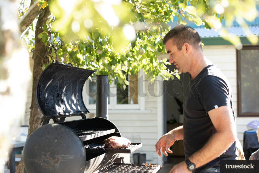Man Barbequing in the Backyard