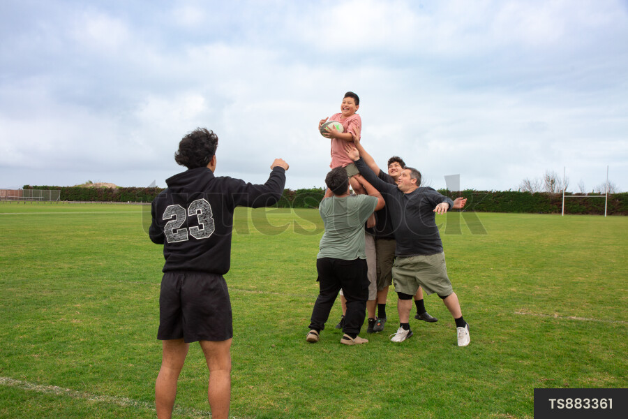 Family Playing Rugby at School Field