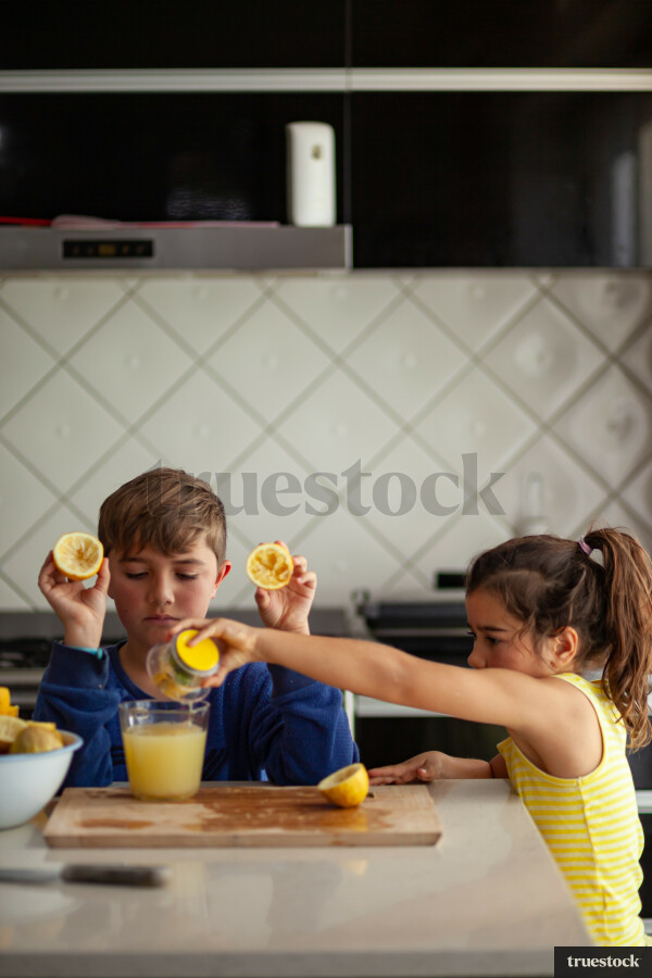Young children making lemondade
