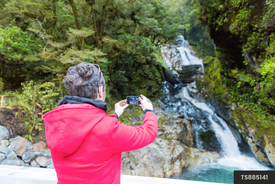Woman Taking Photo of Falls