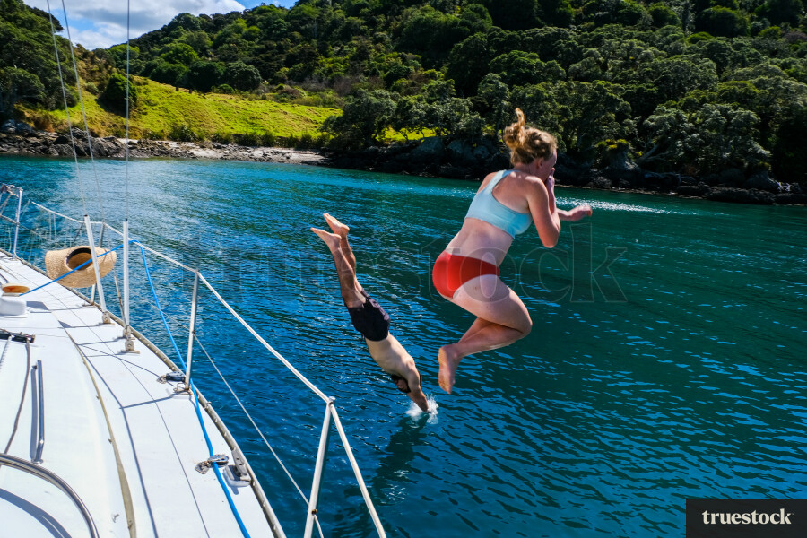 Man and woman jumping off boat