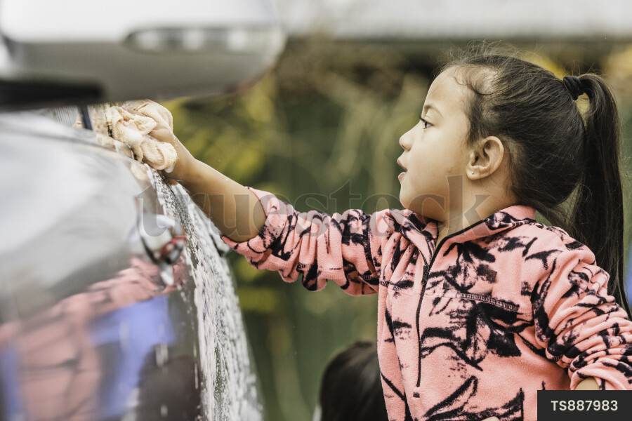 Maori girl washing car at home