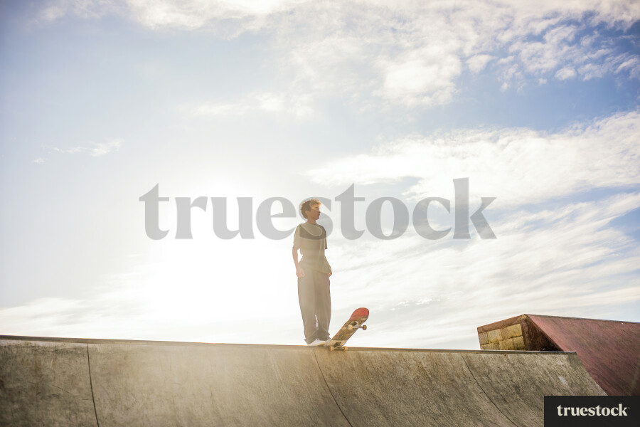 Young Boy at the top of Skateboard Ramp