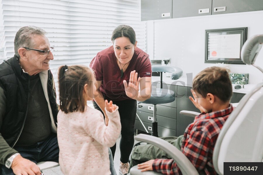 Dentist giving high-five to patient in clinic