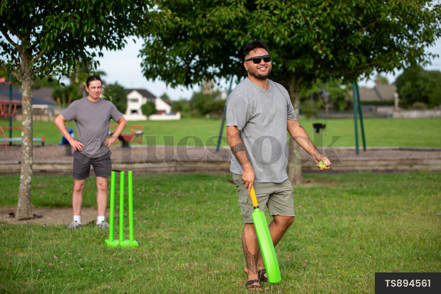 Friends playing cricket at park
