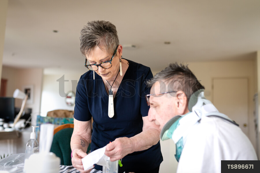 Health carer giving medicine to patient with neck brace