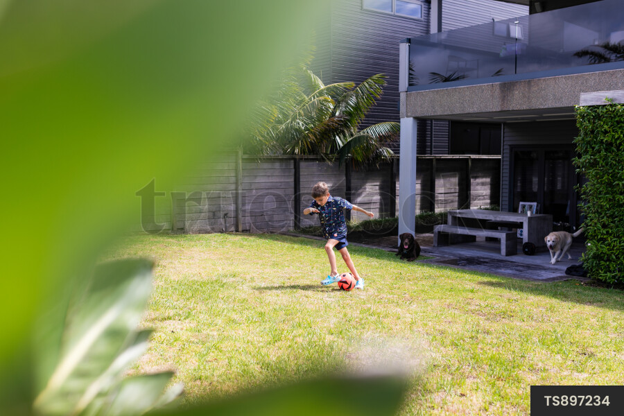 Boy playing with soccer ball on lawn
