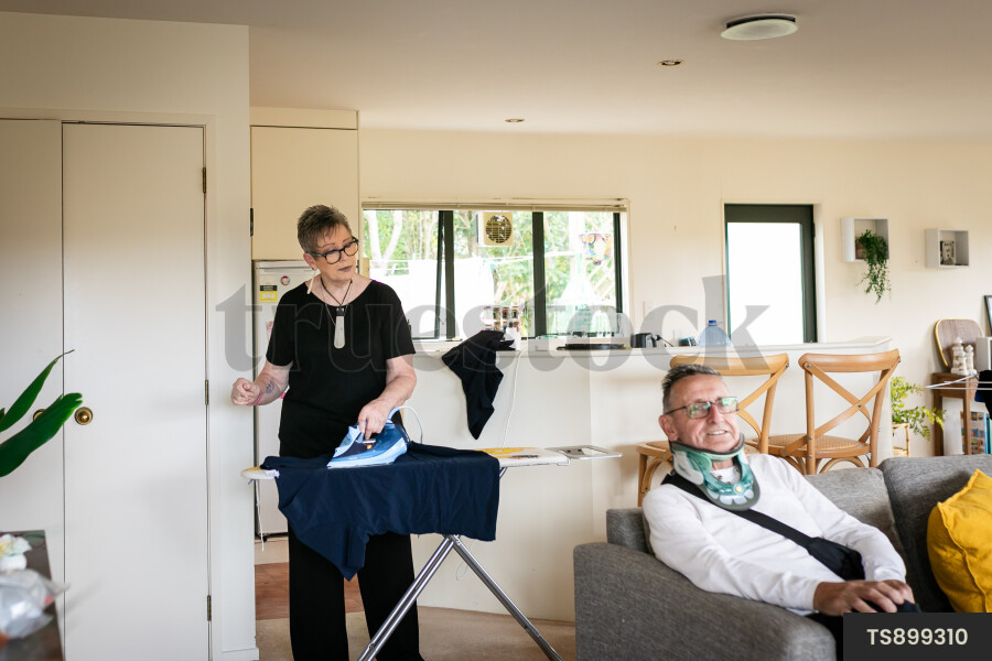 Health carer ironing clothes for patient