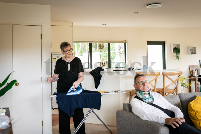 Health carer ironing clothes for patient