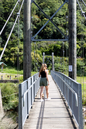 Woman walking dog on bridge